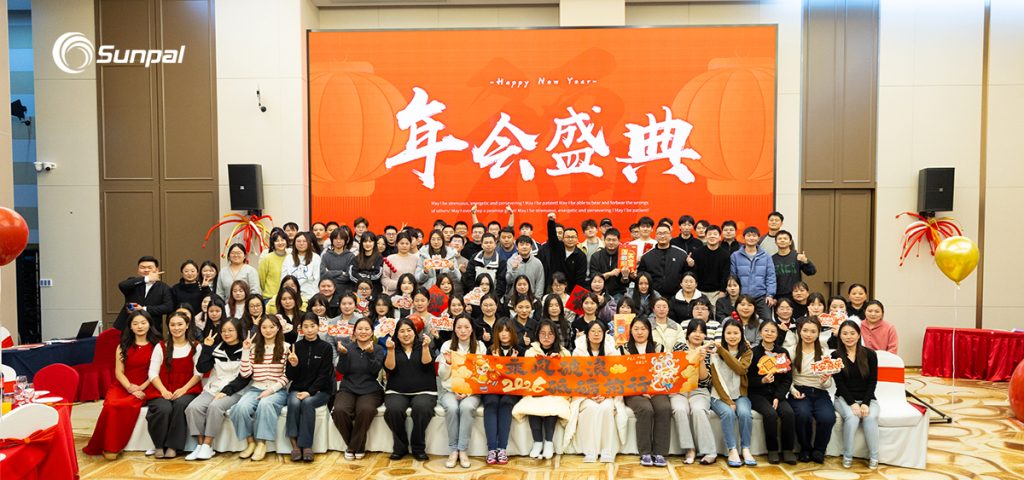 Team photo at Sunpal annual meeting with festive Chinese New Year decorations and lanterns.